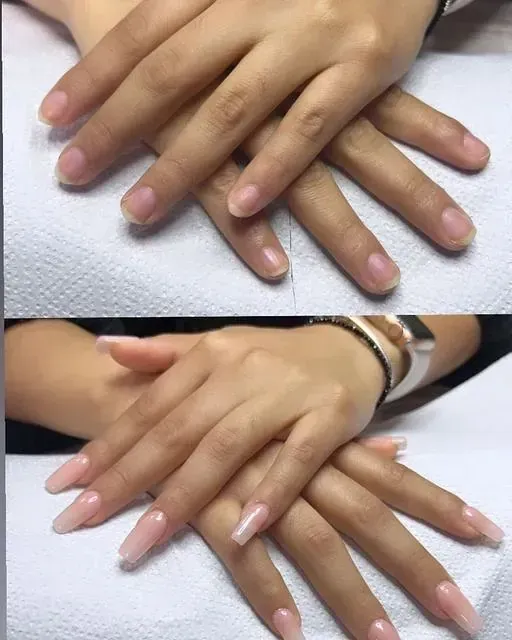 Un primer plano de las manos de una mujer con uñas rosas.