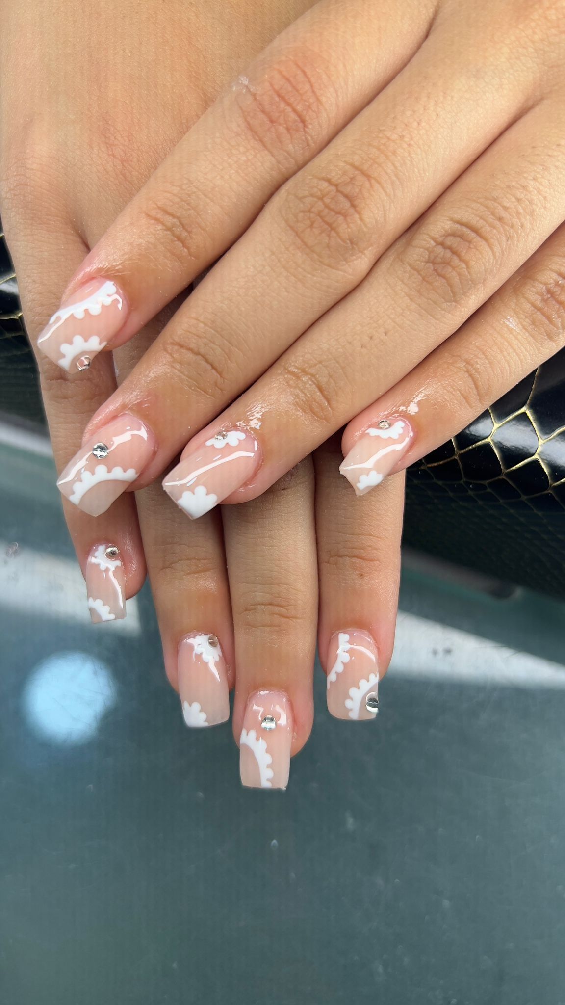Un primer plano de las uñas de una mujer con manicura francesa.