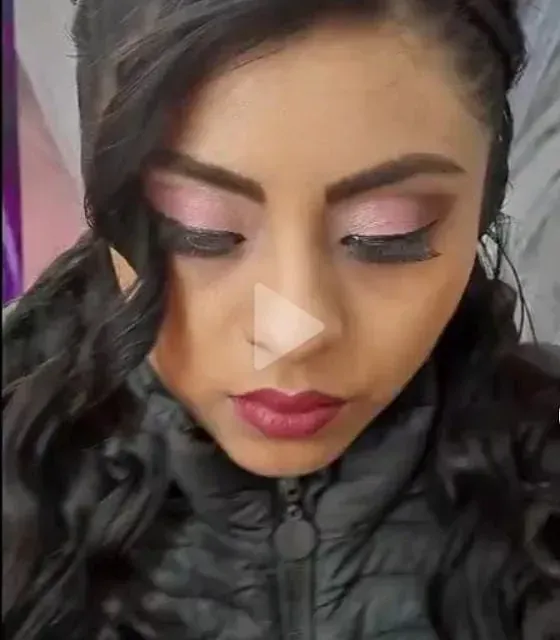 Un primer plano del rostro de una mujer con sombra de ojos rosa.