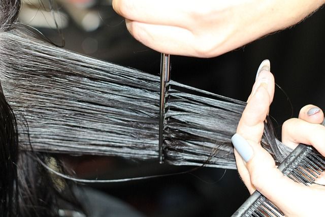 Una mujer se está cortando el pelo en la peluquería.