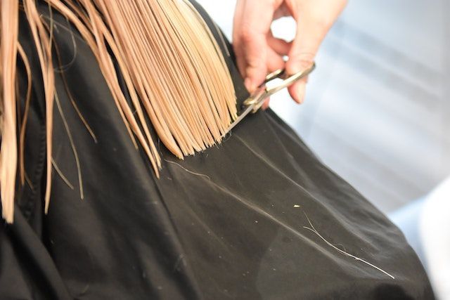 Una mujer se está cortando el pelo en la peluquería.