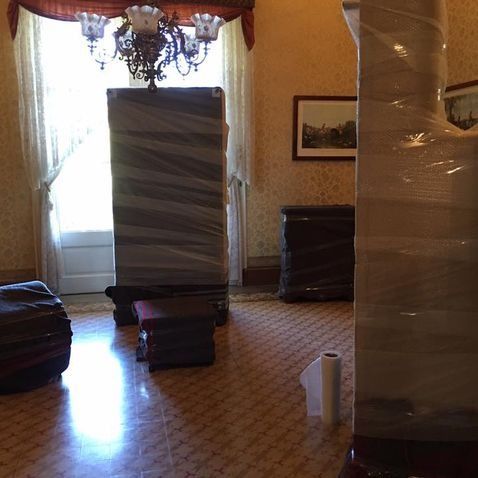 Muebles envueltos en plástico dentro de una habitación.