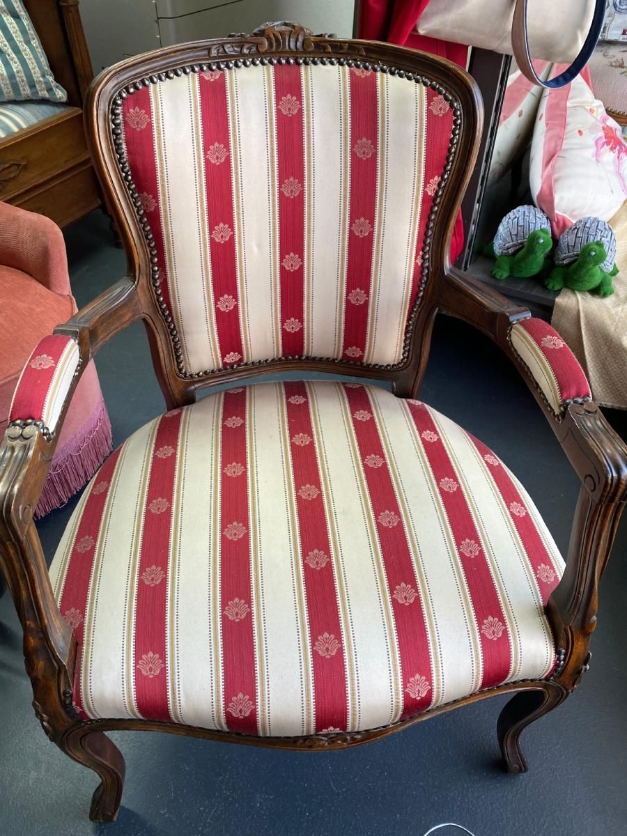 Dunkler Holzstuhl mit Verzierungen und gestreifter Polsterung