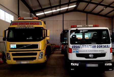 Dos grúas están estacionadas una al lado de la otra en un almacén.