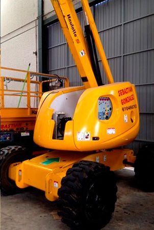 Un elevador hidráulico amarillo está estacionado en un garaje.