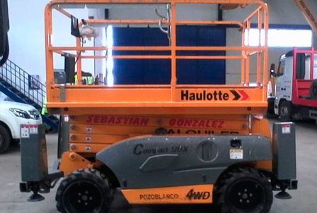 Un elevador de tijera Haulotte está estacionado en un garaje