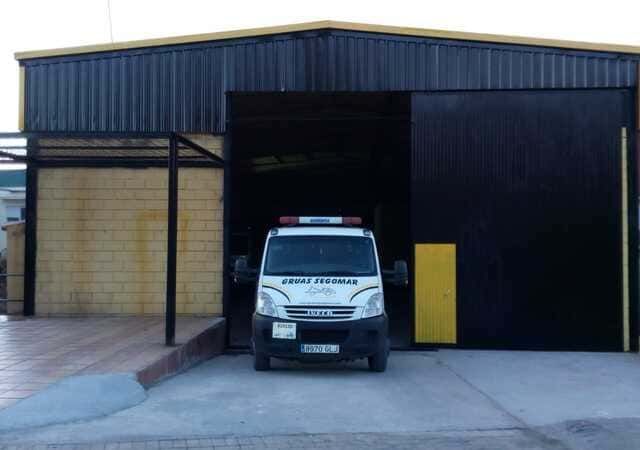 Una grúa blanca está estacionada frente a un edificio.