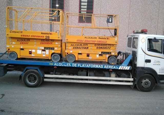 Una grúa con dos elevadores de tijera en la parte trasera.