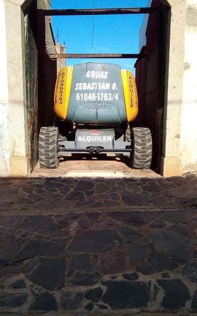 Un vehículo gris y amarillo está estacionado en un garaje.