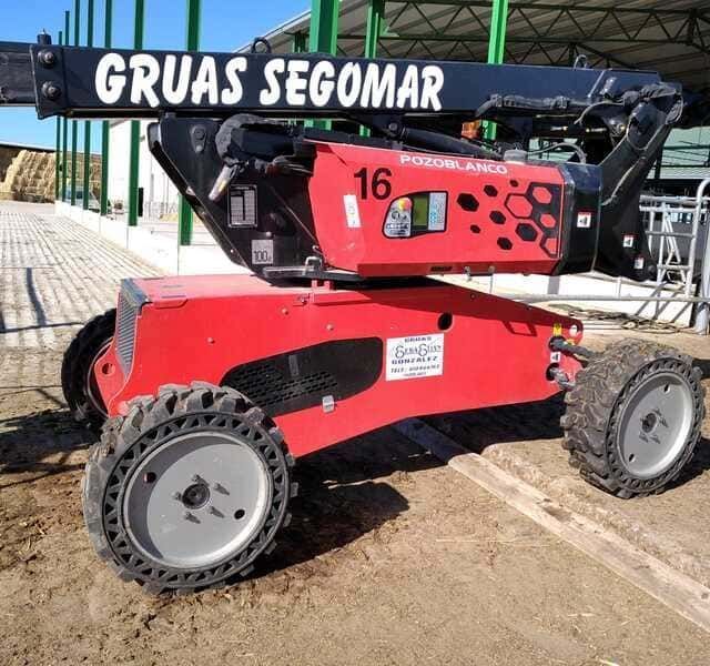 Un vehículo rojo y negro de la grua segomar está estacionado en la tierra
