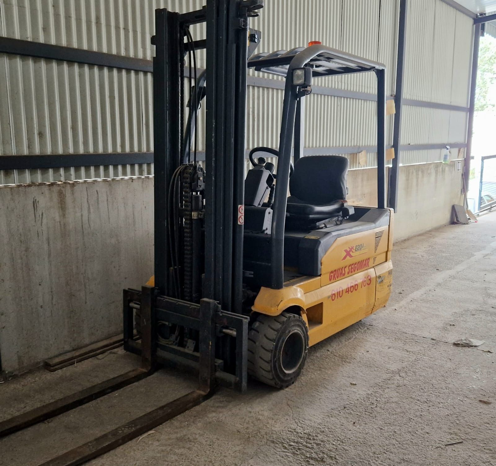 Una carretilla elevadora amarilla y negra está estacionada en un almacén