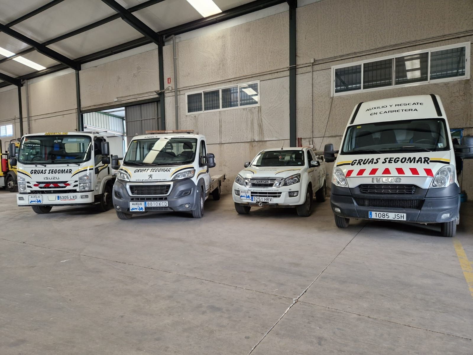 Una fila de grúas están estacionadas en un almacén.