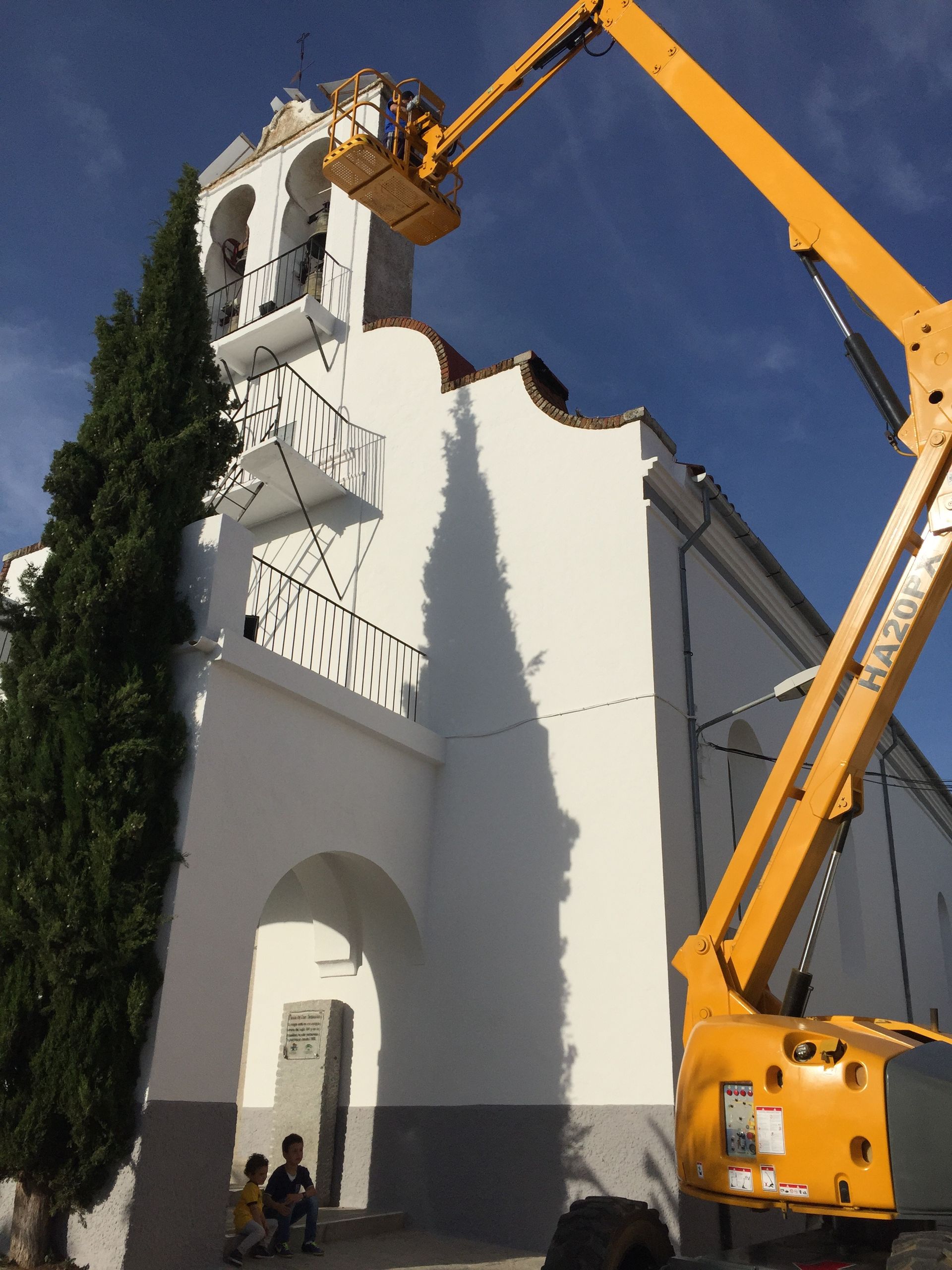 Una grúa amarilla está levantando un edificio blanco