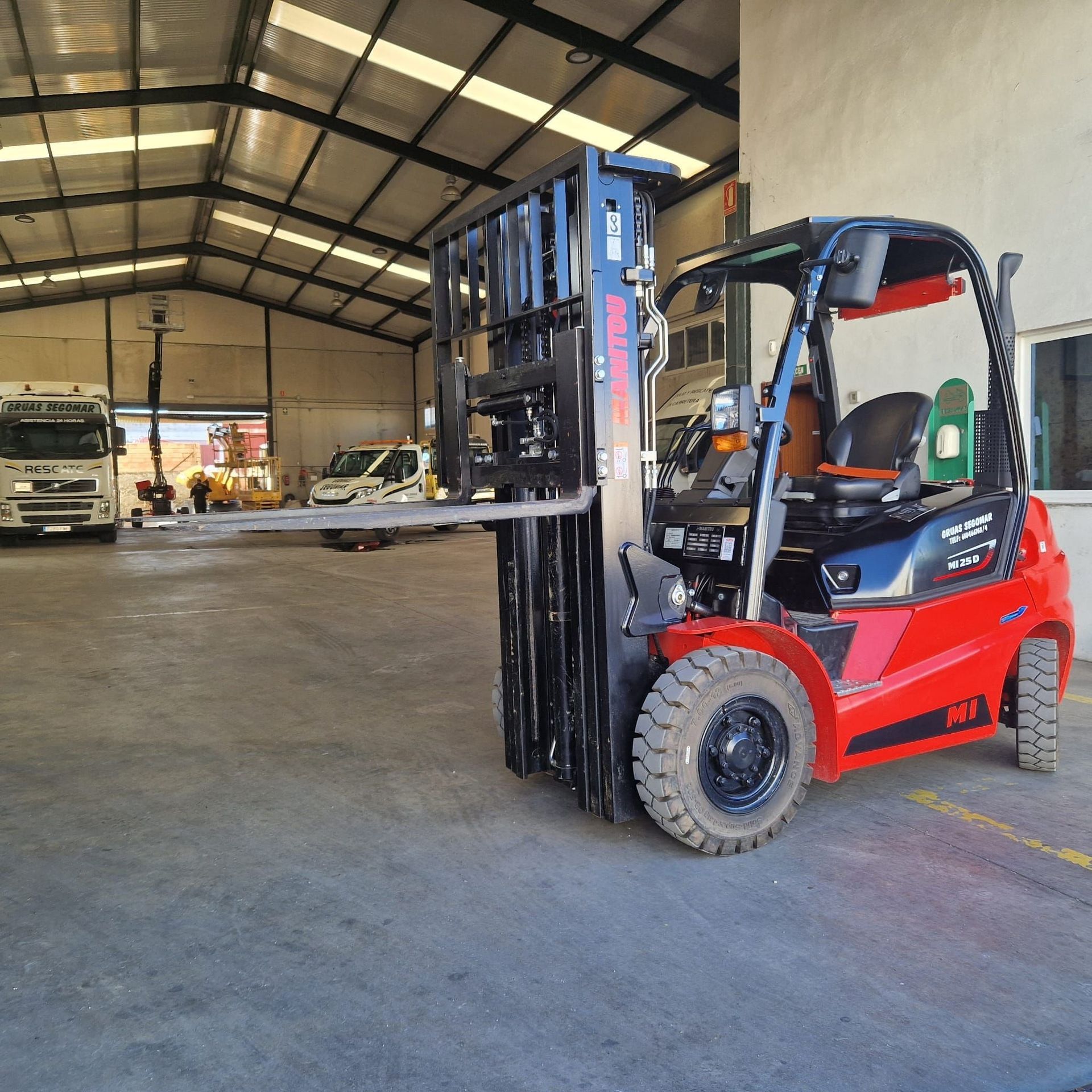 Una carretilla elevadora roja está estacionada frente a un edificio