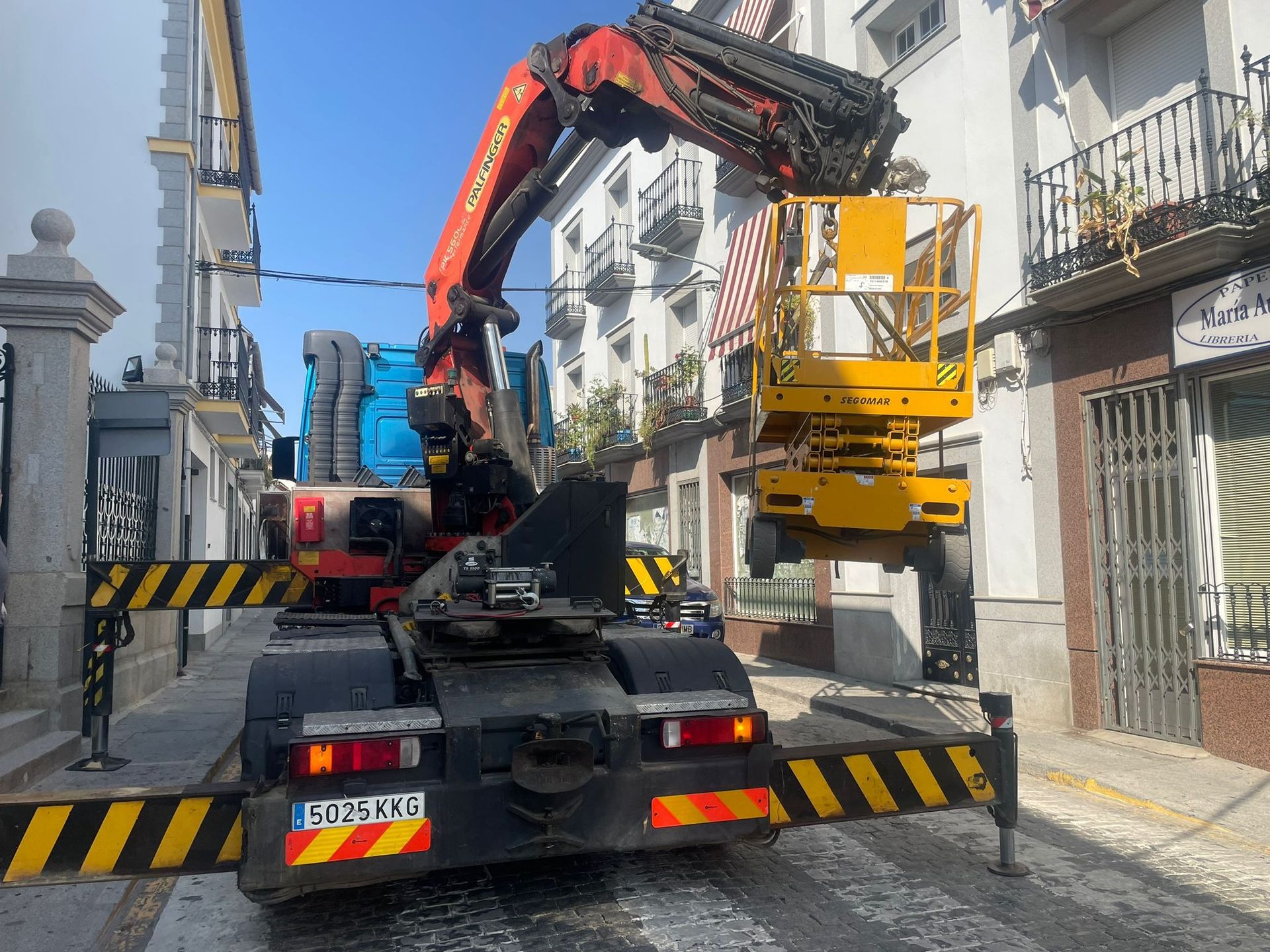 Un camión con una grúa en la parte trasera está estacionado al costado de la carretera.