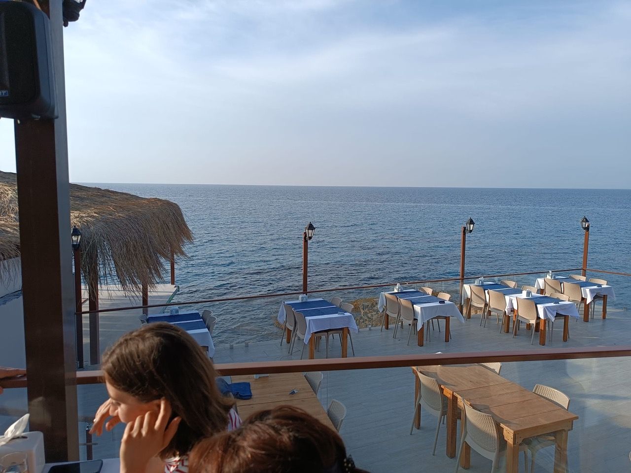 Zypern Restaurant am Strand mit blau weissen Tischen und Blick aufs Meer.