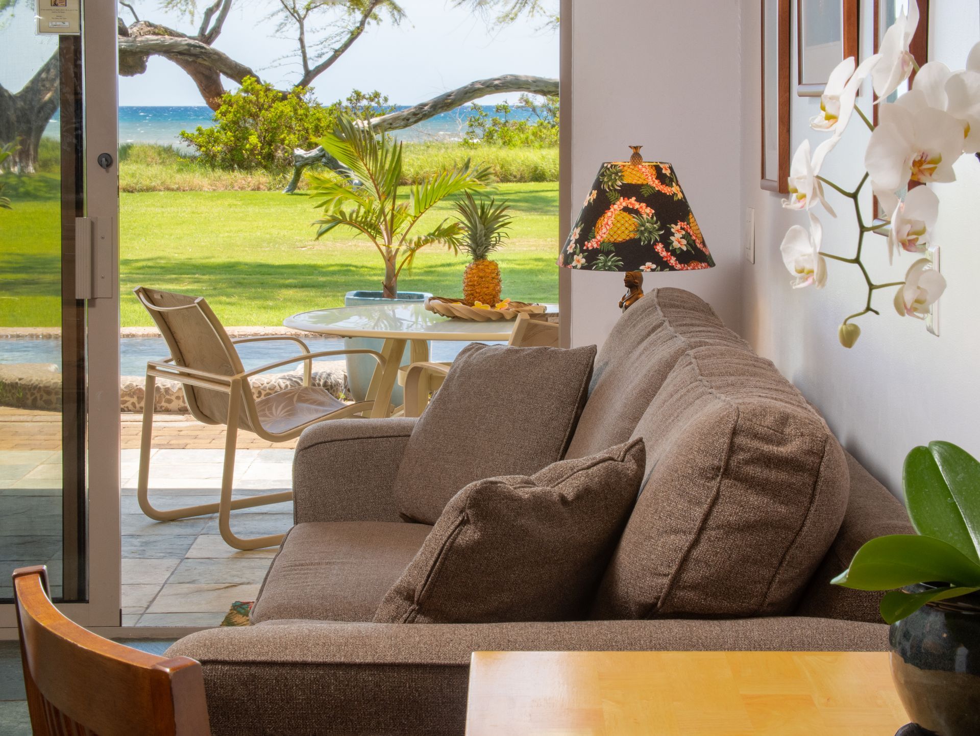 A living room with a couch and a table with a view of the ocean