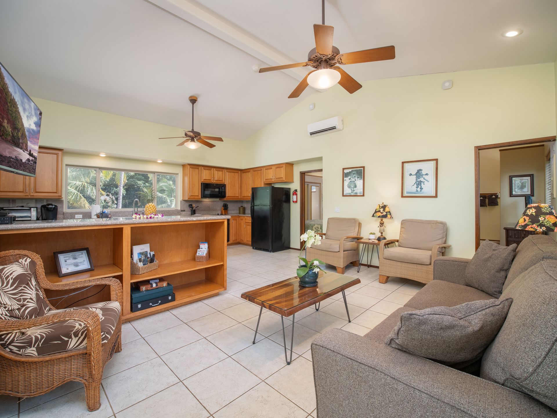 A living room with a couch , chairs , coffee table and ceiling fan.