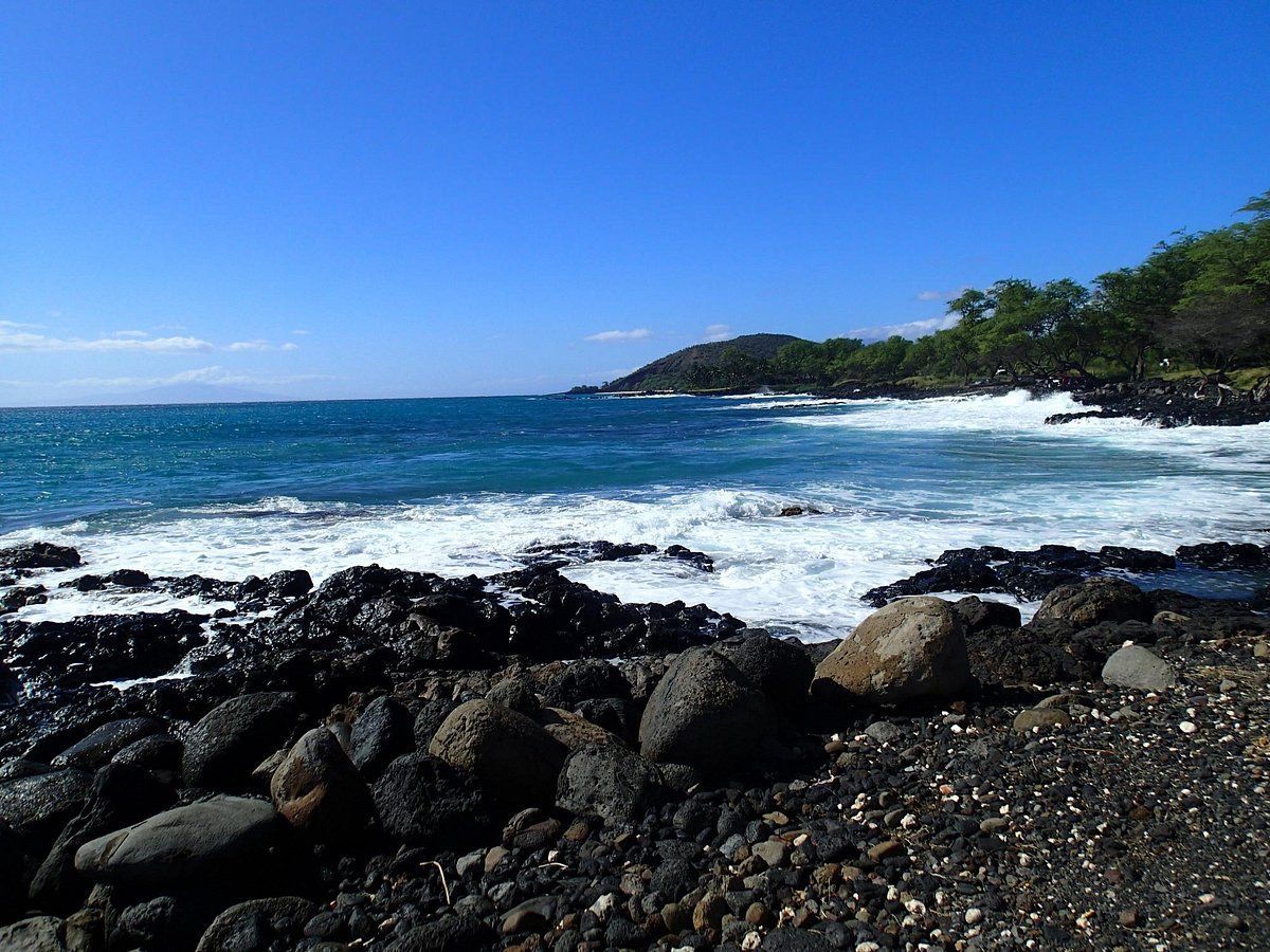 A rocky beach with waves crashing on the shore