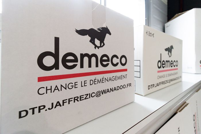 Cartons Demeco sur meuble blanc