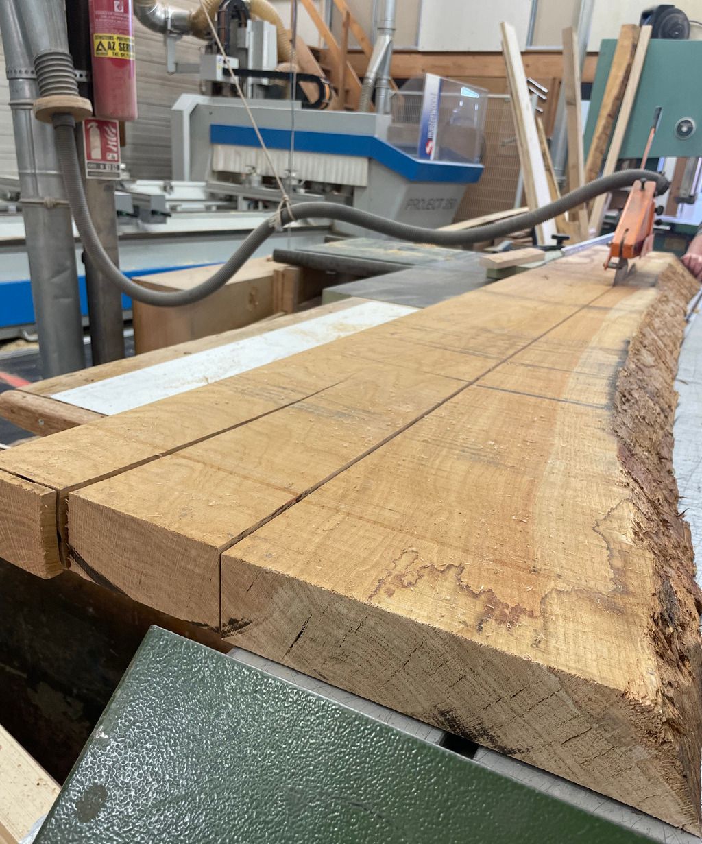 Planche de bois massif entrain d'être coupée