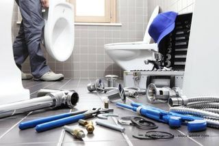 Mitarbeiter von Sa­ni­tär Preiss­ler repariert Toilette