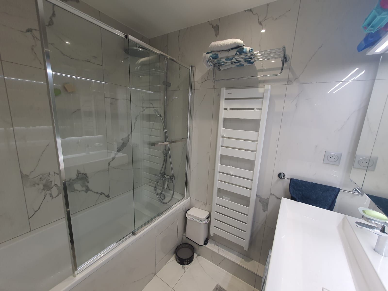 Baignoire avec vitre de protection pour prendre une douche.