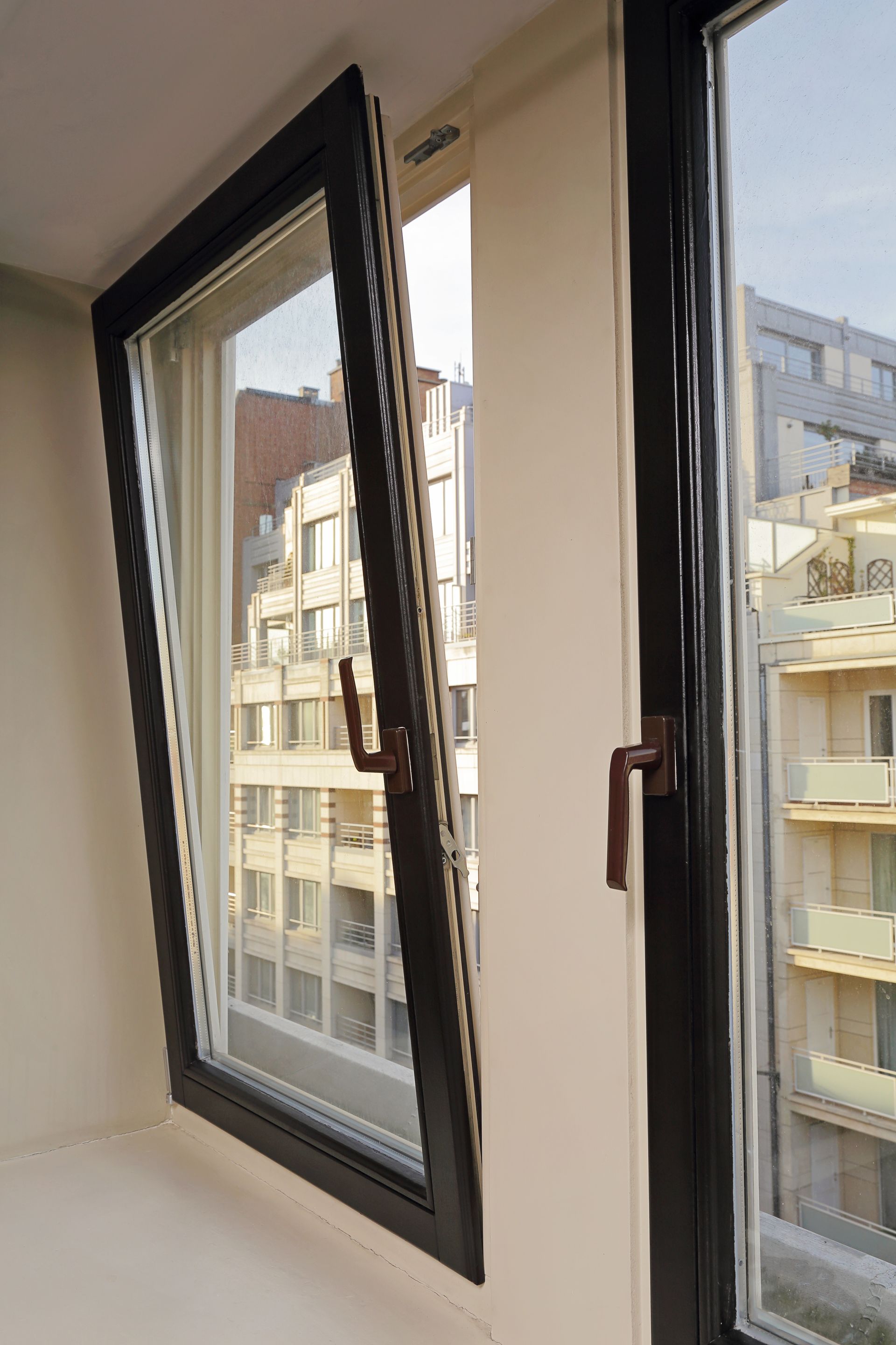 Fenêtre oscillobattante noire entrouverte.