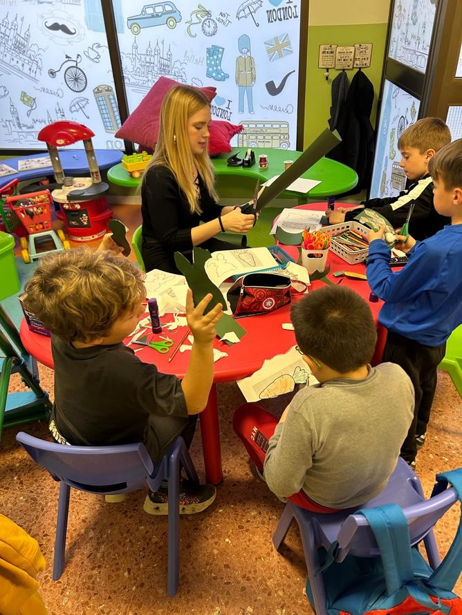 Un grupo de niños están sentados alrededor de una mesa roja.