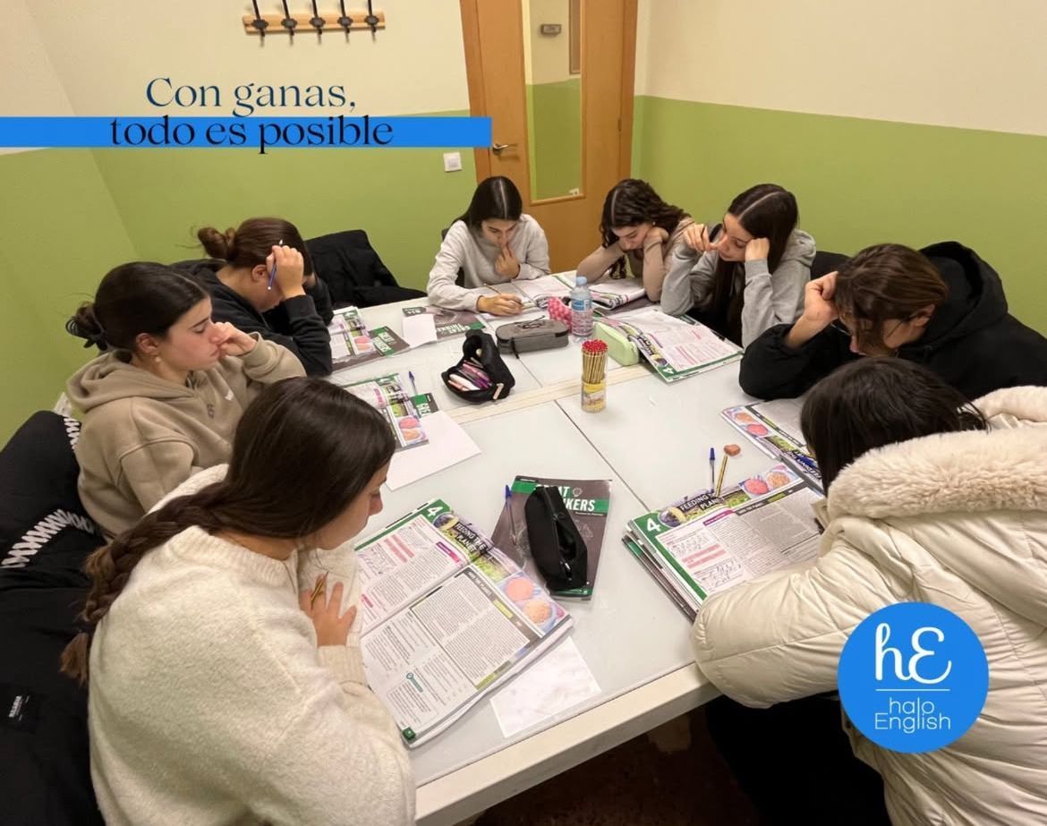 Un grupo de mujeres jóvenes están sentadas alrededor de una mesa.