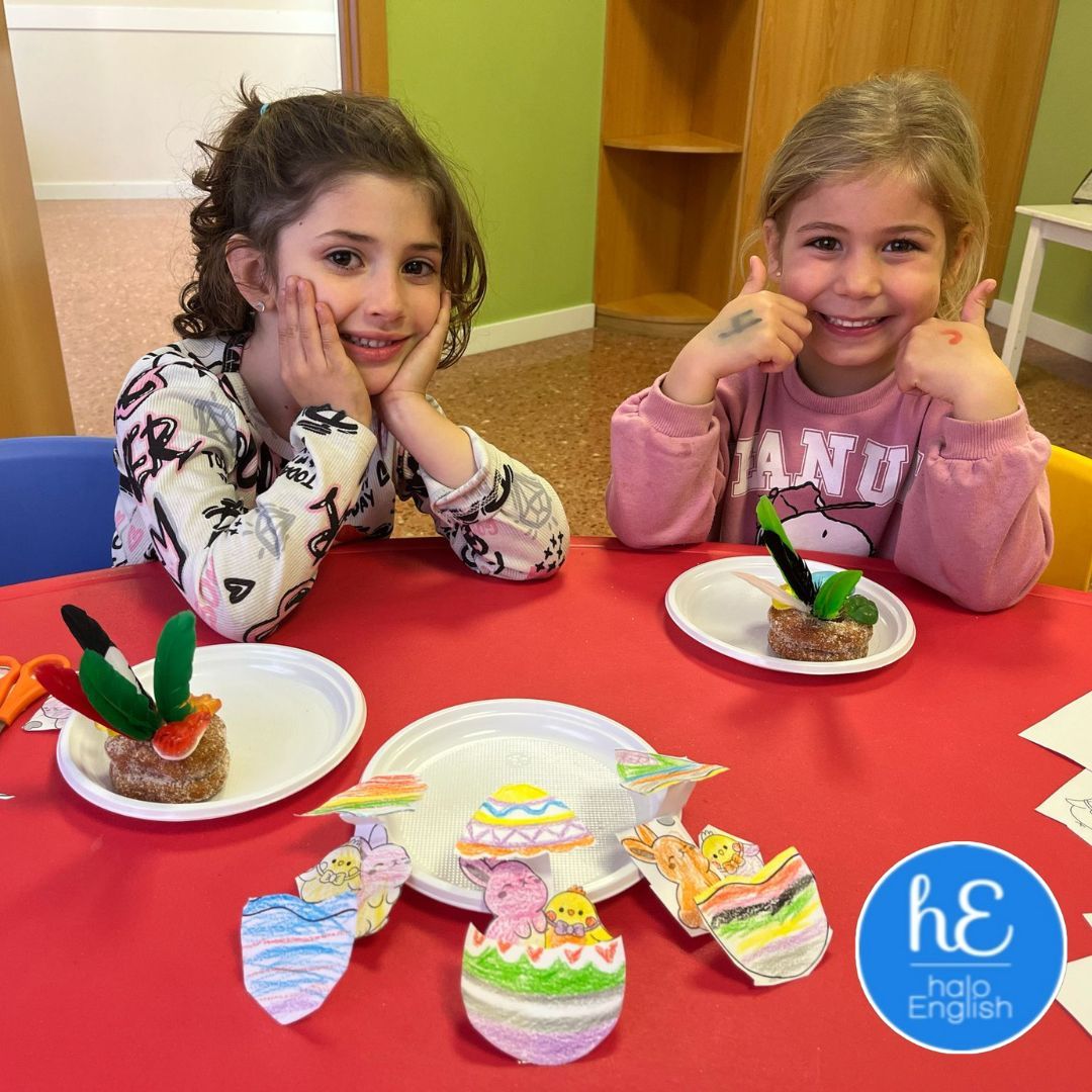 Dos chicas jóvenes están sentadas en una mesa con platos de comida.