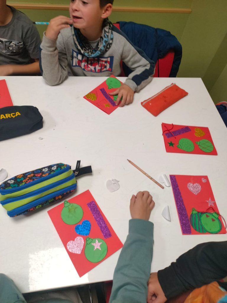 Un niño está sentado en una mesa con un estuche que dice barça.