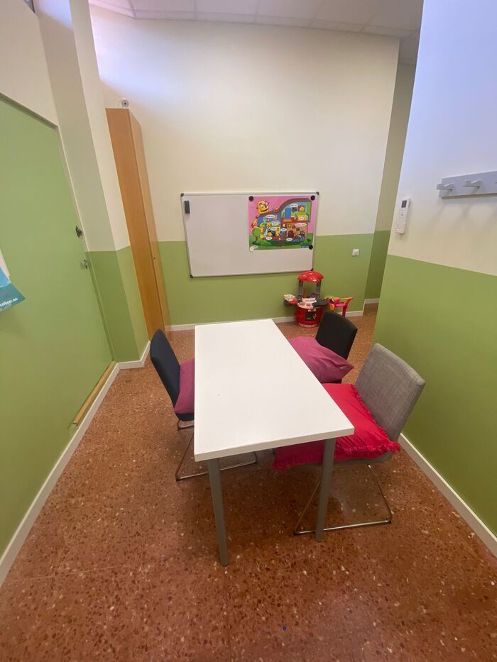 Una pequeña habitación con una mesa y sillas.