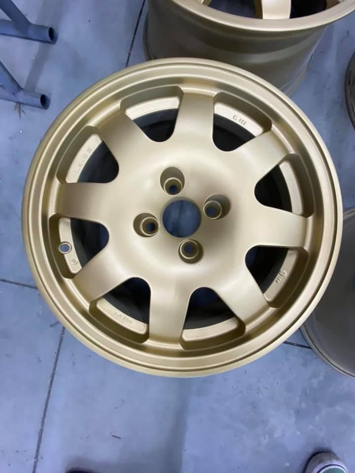 Une jante automobile dorée à quatre écrous.