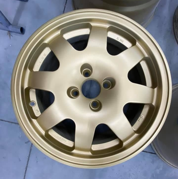 Une jante de voiture dorée à huit rayons.