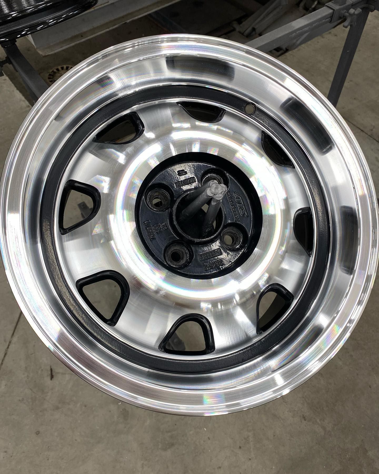 Une roue de voiture à quatre écrous, argentée et noire.