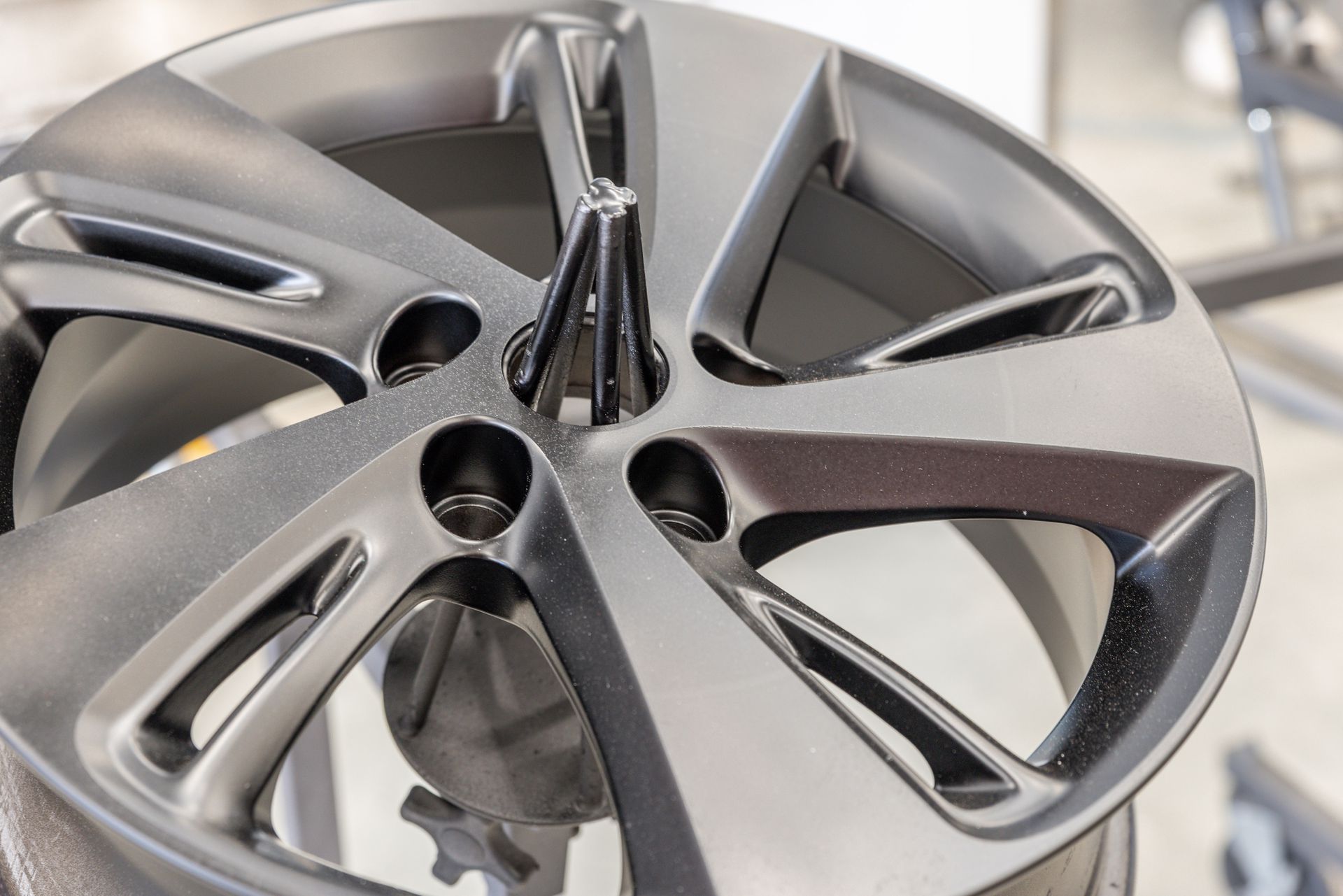 Une jante de voiture mate montée sur un support.