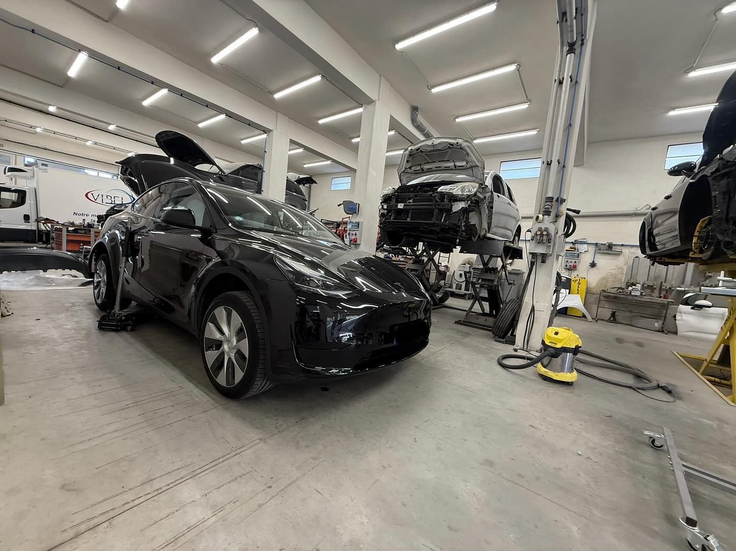 Un SUV électrique noir est garé dans un garage.