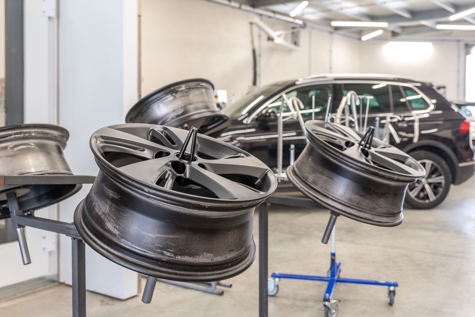 Jantes en alliage noir montées sur un support dans un atelier de réparation automobile.