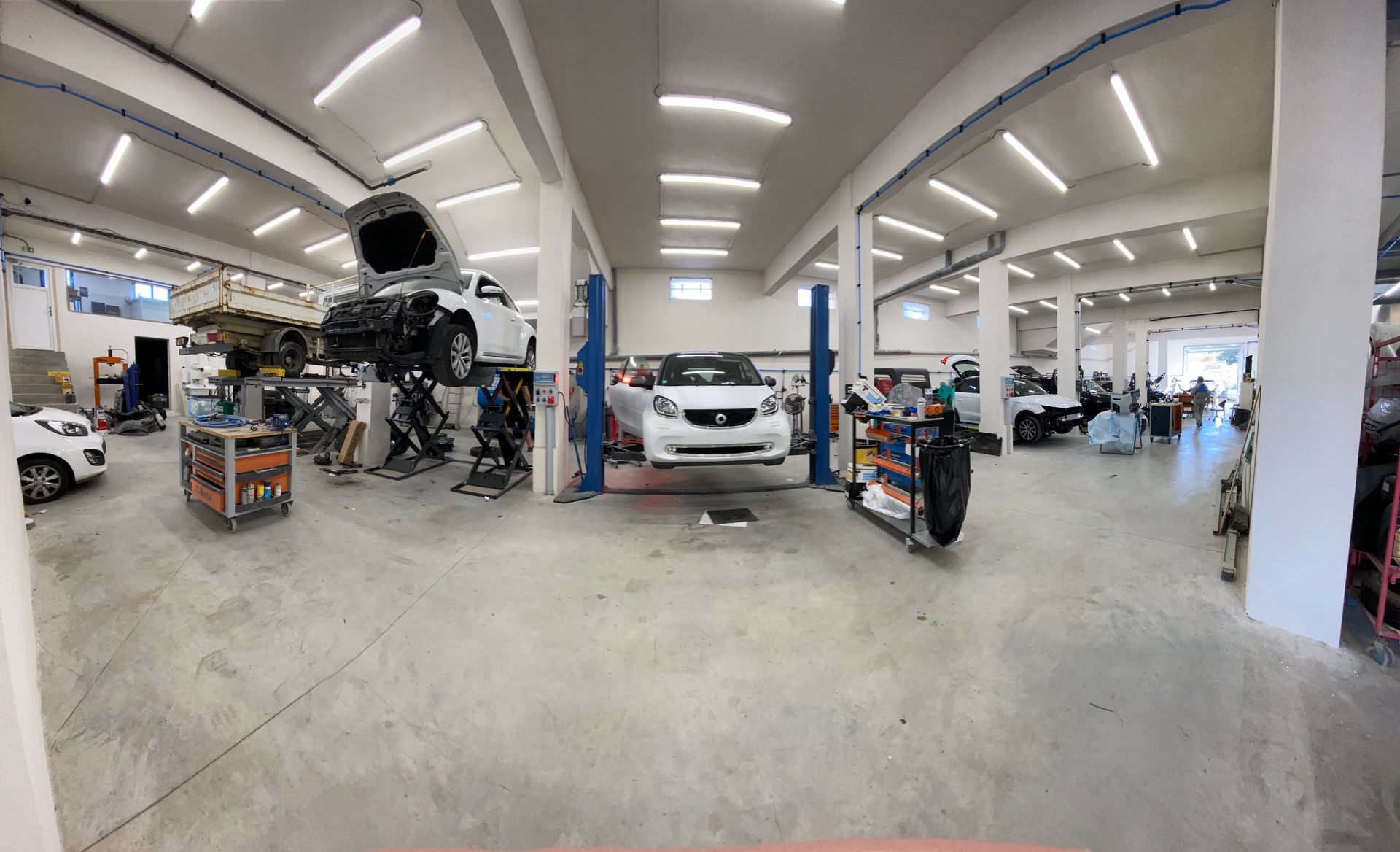 Vue grand angle d'un atelier de réparation automobile lumineux.