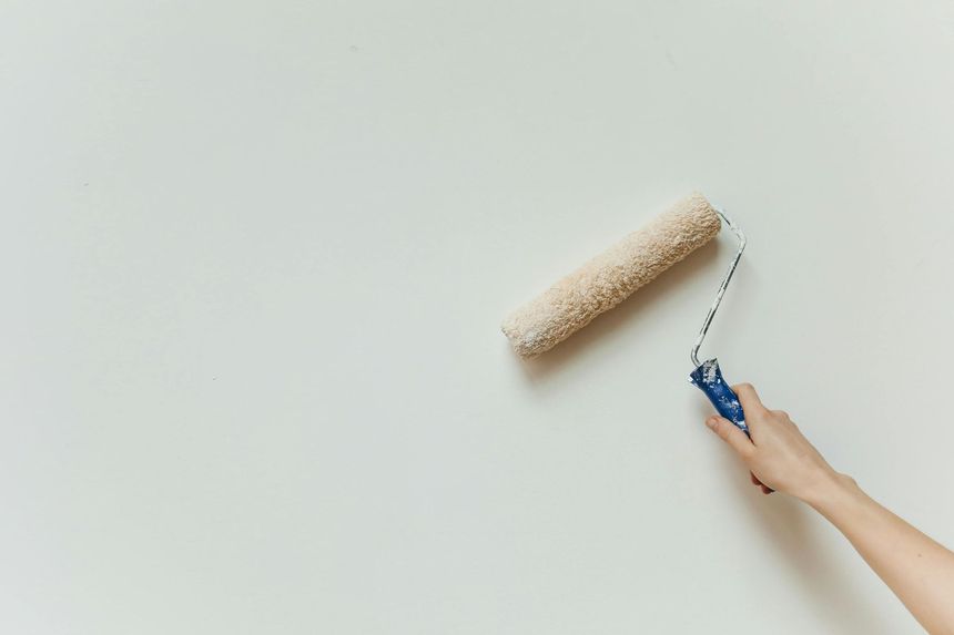 Peinture manuelle appliquée au rouleau sur un mur blanc.