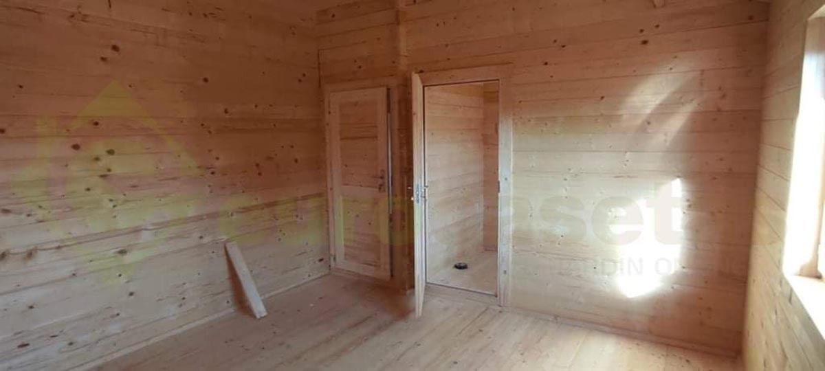 Una habitación de madera con dos puertas y una ventana.