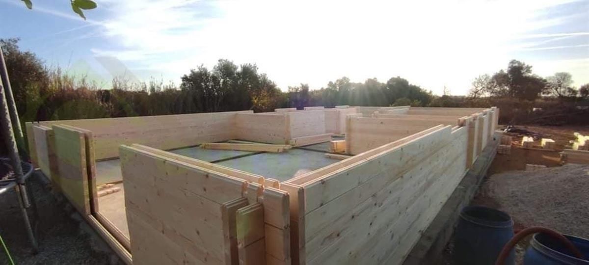 Se está construyendo una gran estructura de madera en medio de un campo.