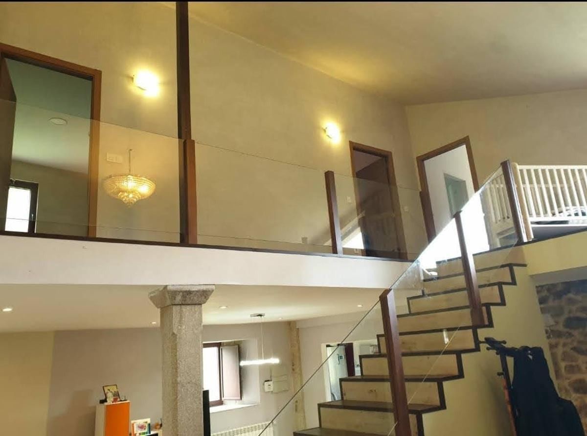 Una escalera en una casa con barandilla de cristal