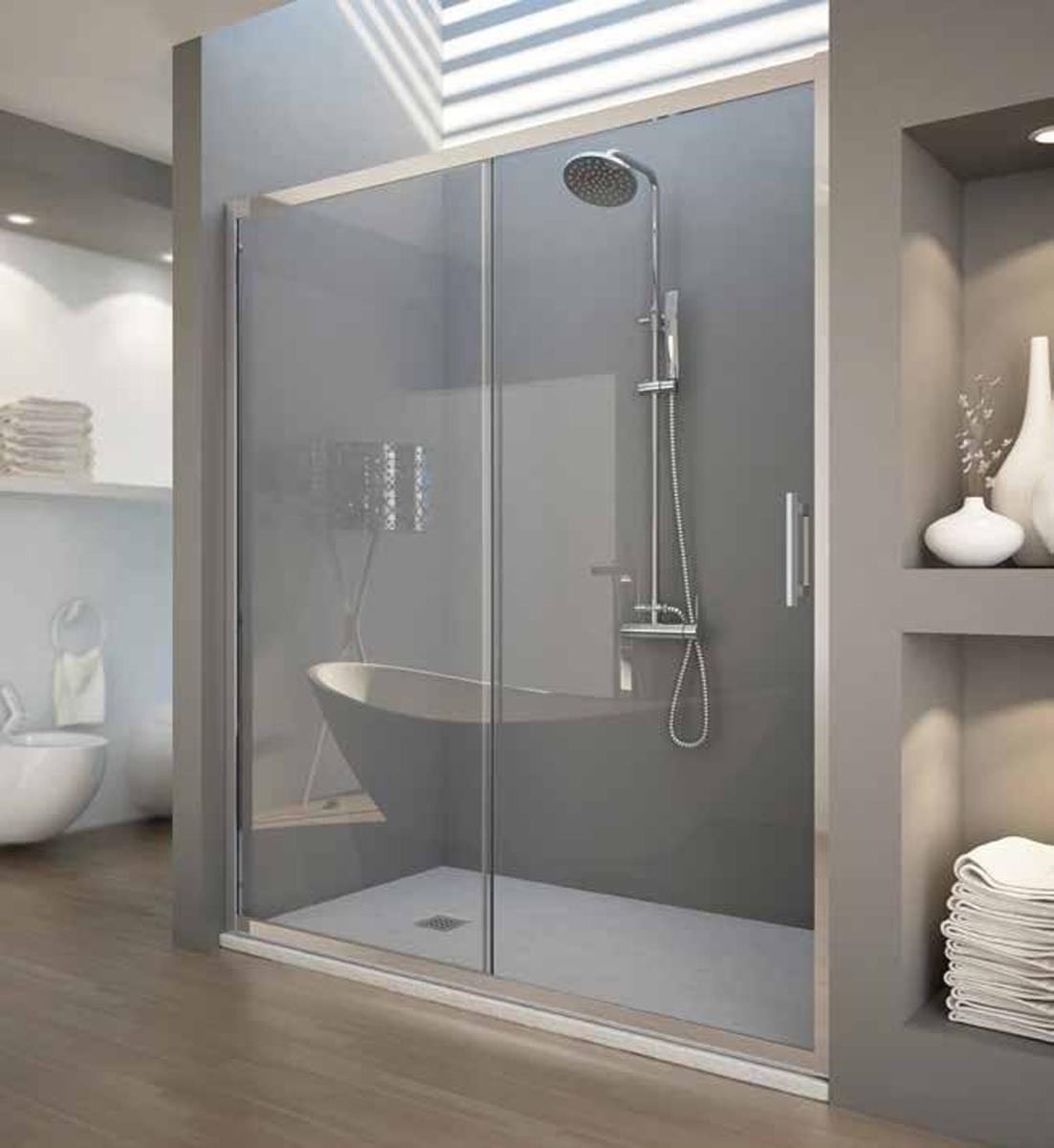 Un baño con puerta de ducha corrediza de cristal y bañera.