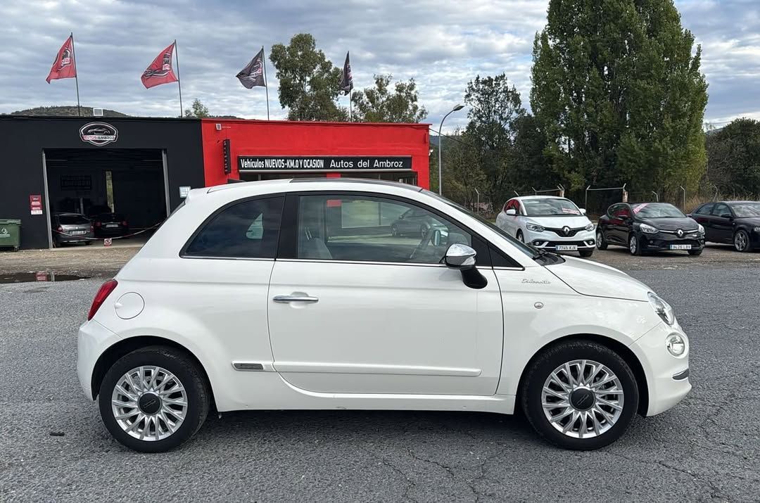 Exterior de un taller de reparación de automóviles con fachada roja y negra, y coches aparcados fuera.