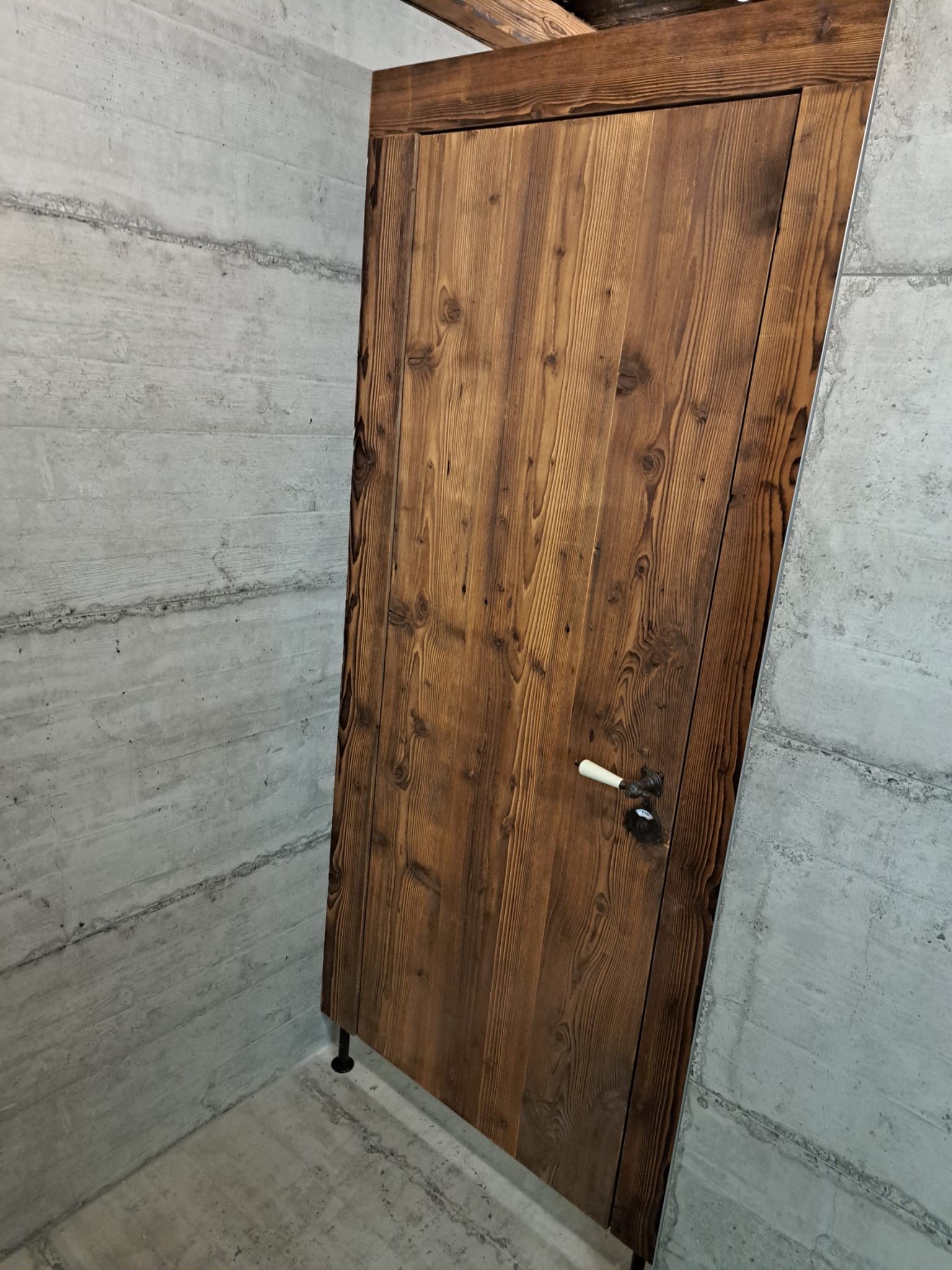 Eine Holztür in einem Raum mit Betonwänden