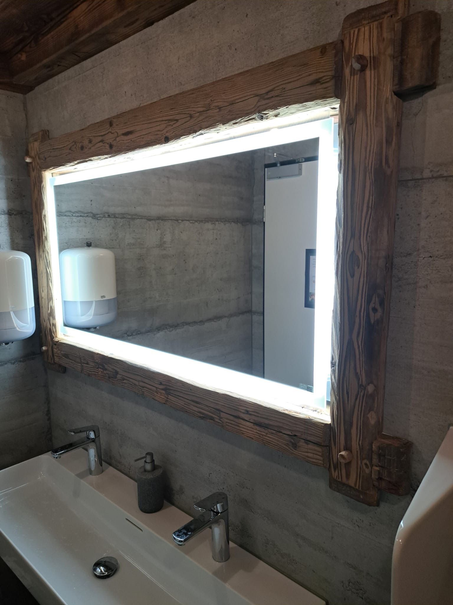 Ein Badezimmer mit einem Waschbecken und einem beleuchteten Spiegel.