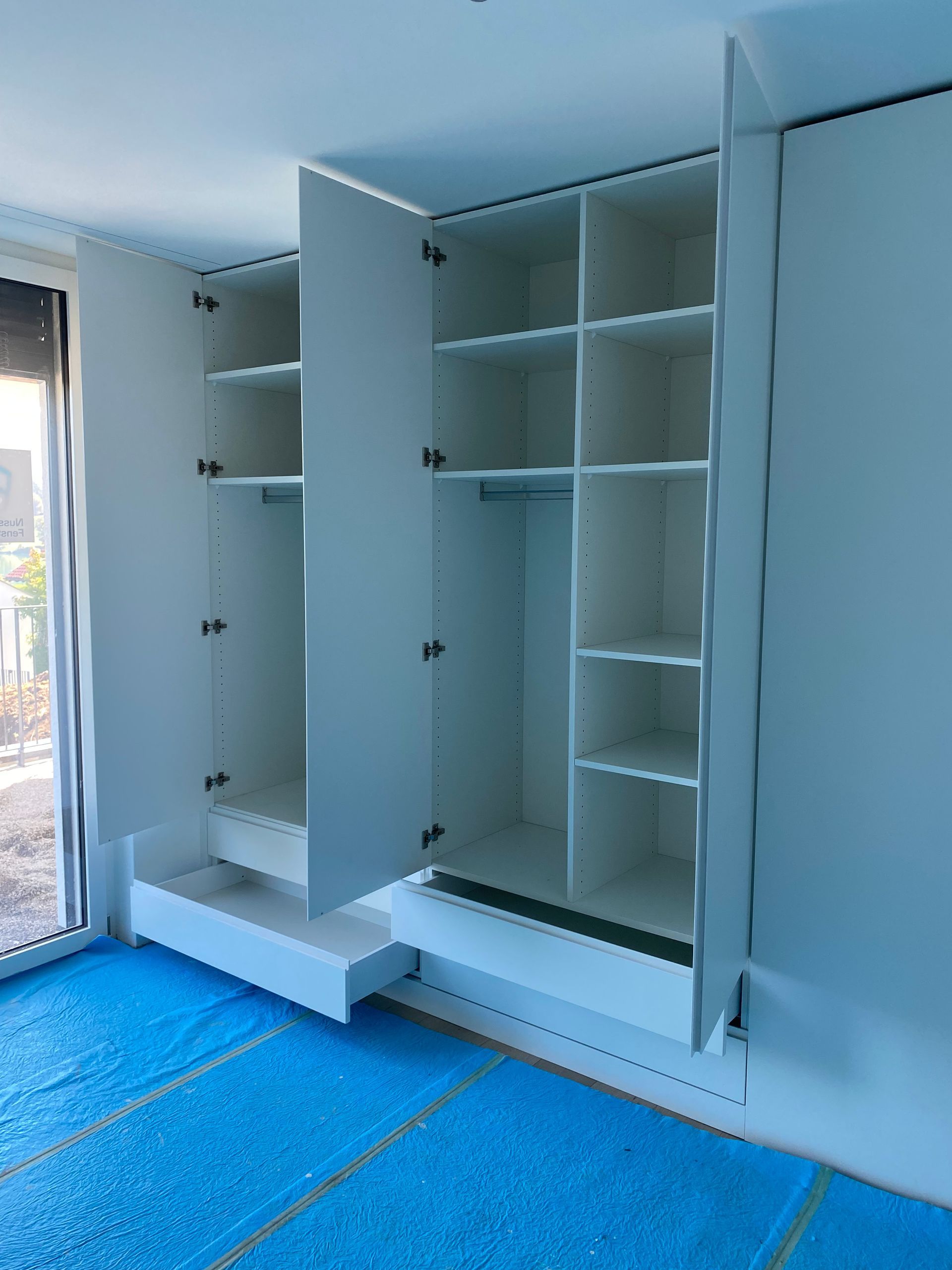 Ein Schrank mit offenen Türen und einer blauen Matte auf dem Boden