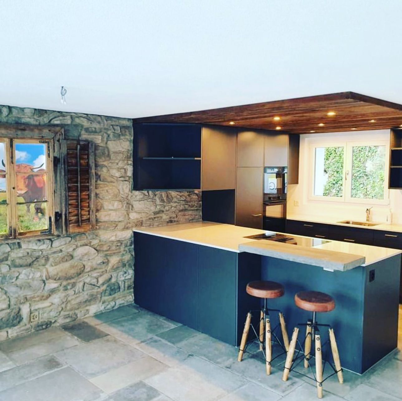 Eine Küche mit einer grossen Insel und zwei Hockern